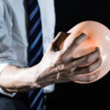 風船を握りつぶそうとしてる男性